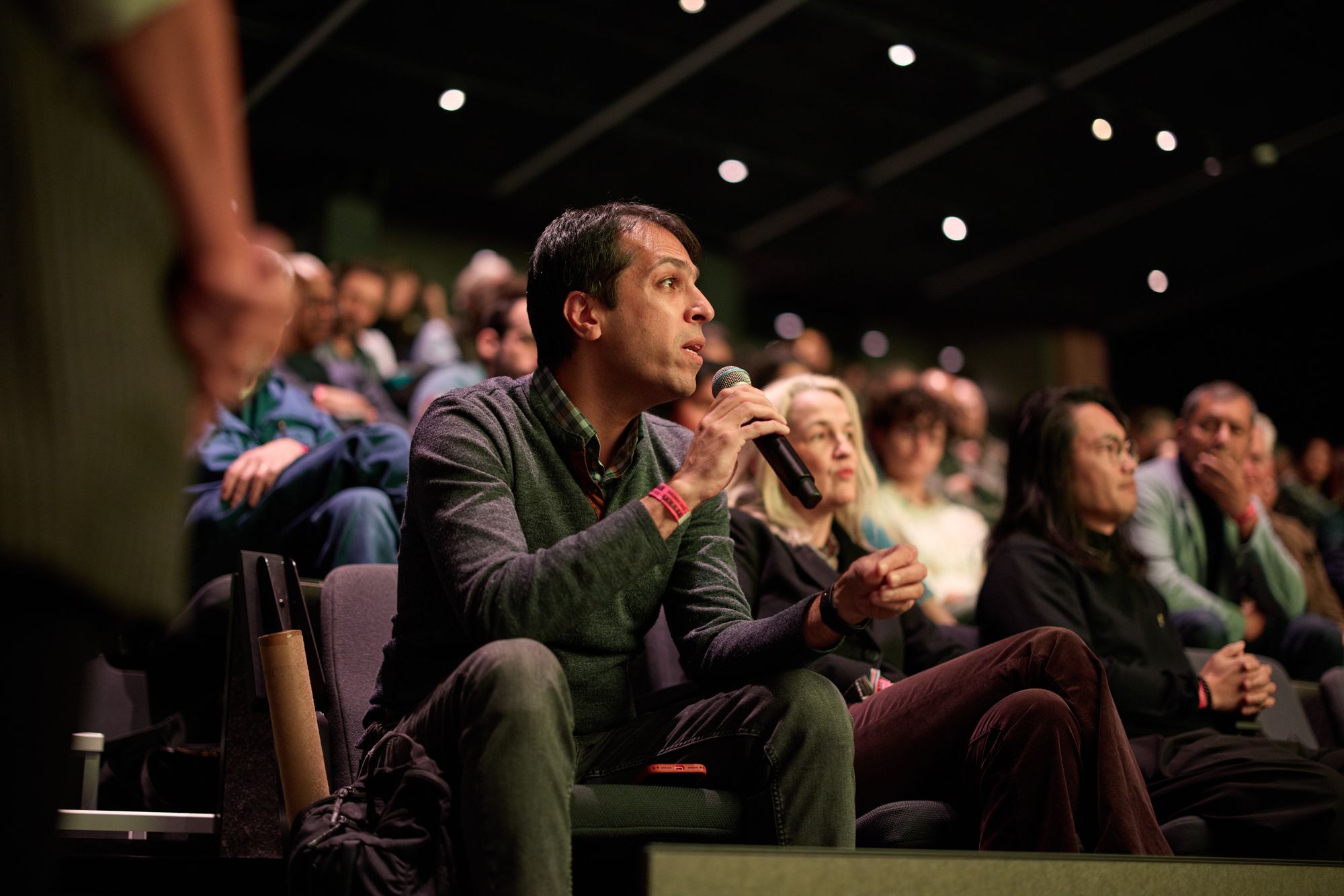 An attendee holding a microphone asks a question.